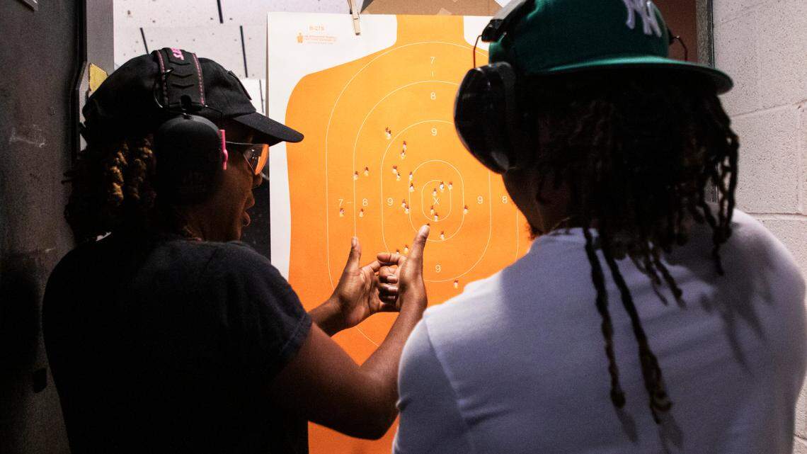 Kisha Kincaid discusses aiming techniques with her student, Taylor Smith, at a gun range in Concord, NC Wednesday August 17, 2022.