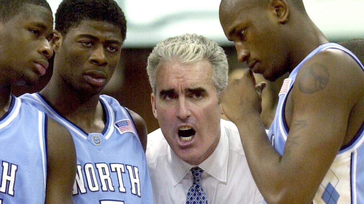 UNC coach Matt Doherty gives instructions to David Noel (left), Jackie Manuel and Jawad Williams during a timeout in the final minutes of second half action in N.C. State’s 86-77 win over UNC in 2003.
