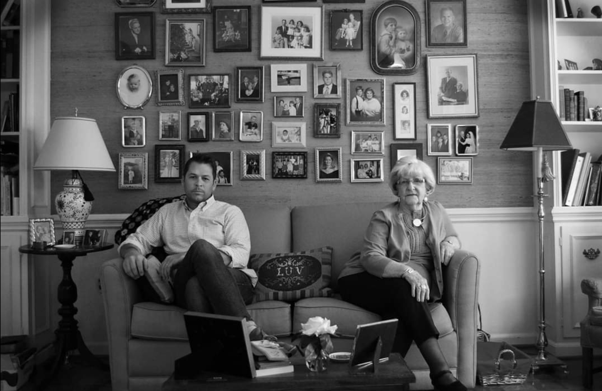 Andrew Taylor, a fourth-generation Charlottean, is shown here with his grandmother, who recently passed away at age 99. Their family photo tree is on the wall behind them. Andrew began photographing Charlotte landmarks in 2001 for The Charlotte Landmark Series. Many of the places are now gone.