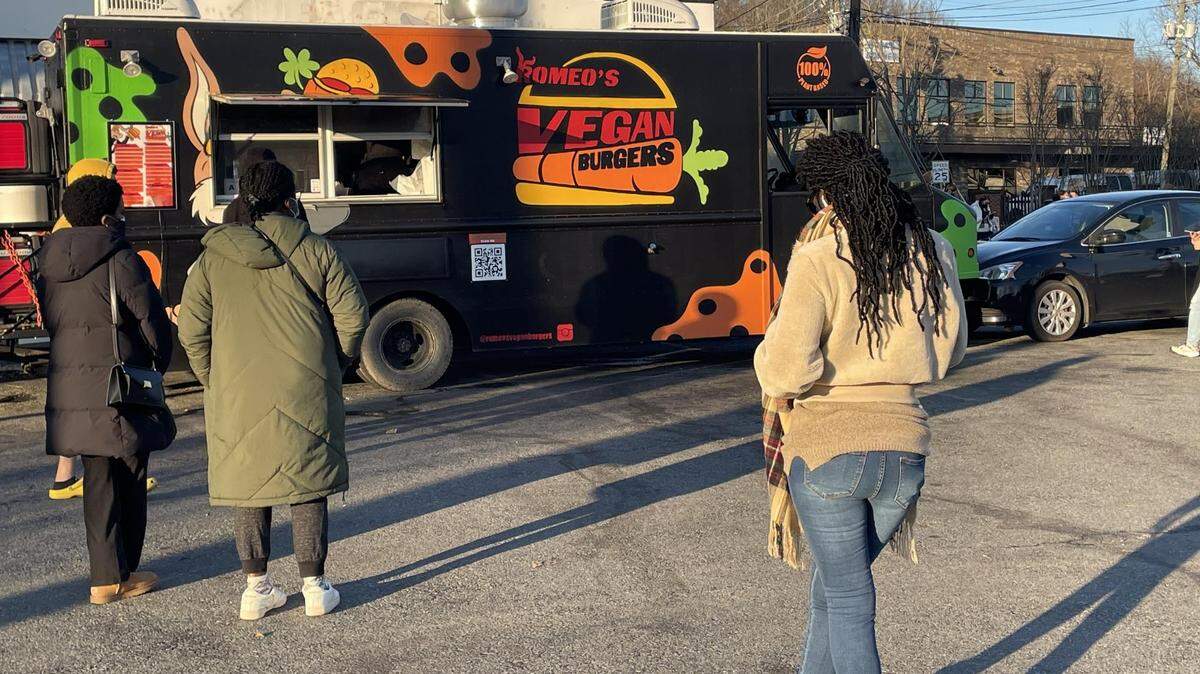 Masked and socially distanced customers wait patiently in line — one that curves around Central Ave.