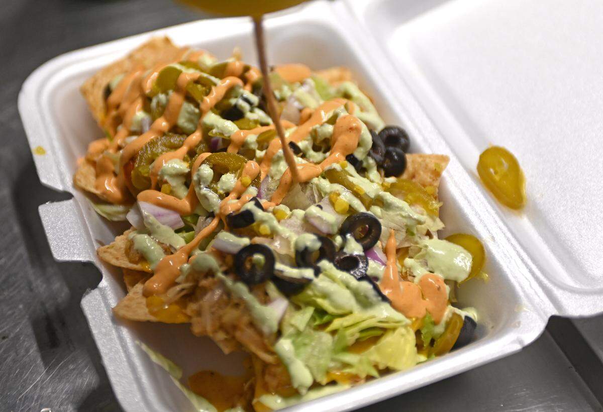 Executive Chef Marco Boykin prepares an order of ultimate loaded nachos inside the Ve-Go Food Truck on Thursday, January 27, 2022. Chef Akil Courtney and executive chef Marco Boykin are local Black vegan chefs. 