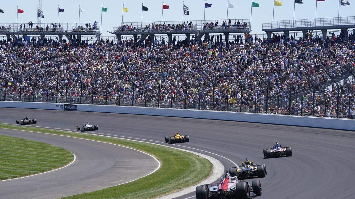 Fans watch as cars go through Turn 1 during the Indianapolis 500 auto race at Indianapolis Motor Speedway on May 30. Legendary Indy 500 broadcaster Bob Jenkins died Monday.
