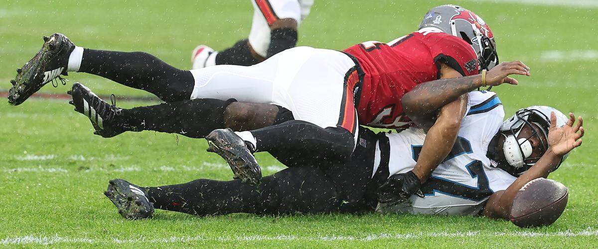 Carolina Panthers wide receiver Xavier Legette, bottom, can only watch the ball skip on the rain covered grass after missing a pass from quarterback Bryce Young during action against the Tampa Bay Buccaneers at Raymond James Stadium in Tampa, FL. on Saturday, January 3, 2026. The Buccaneers defeated the Panthers 16-14.