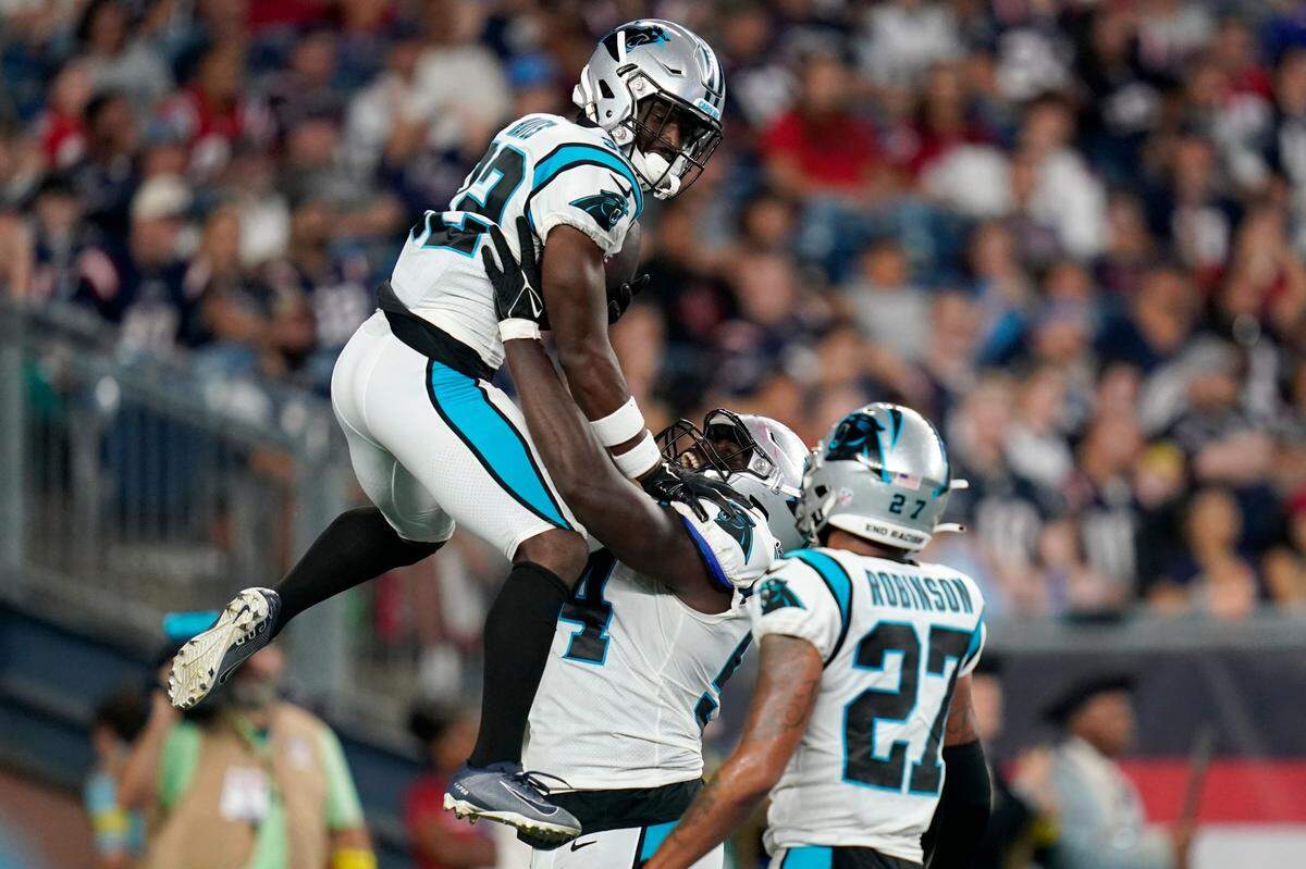 Carolina Panthers cornerback Tae Hayes, left, celebrates with defensive tackle Daviyon Nixon, center, and safety Kenny Robinson, right, after his touchdown on an interception during the second half of the team’s preseason NFL football game against the New England Patriots, Friday, Aug. 19, 2022, in Foxborough, Mass.