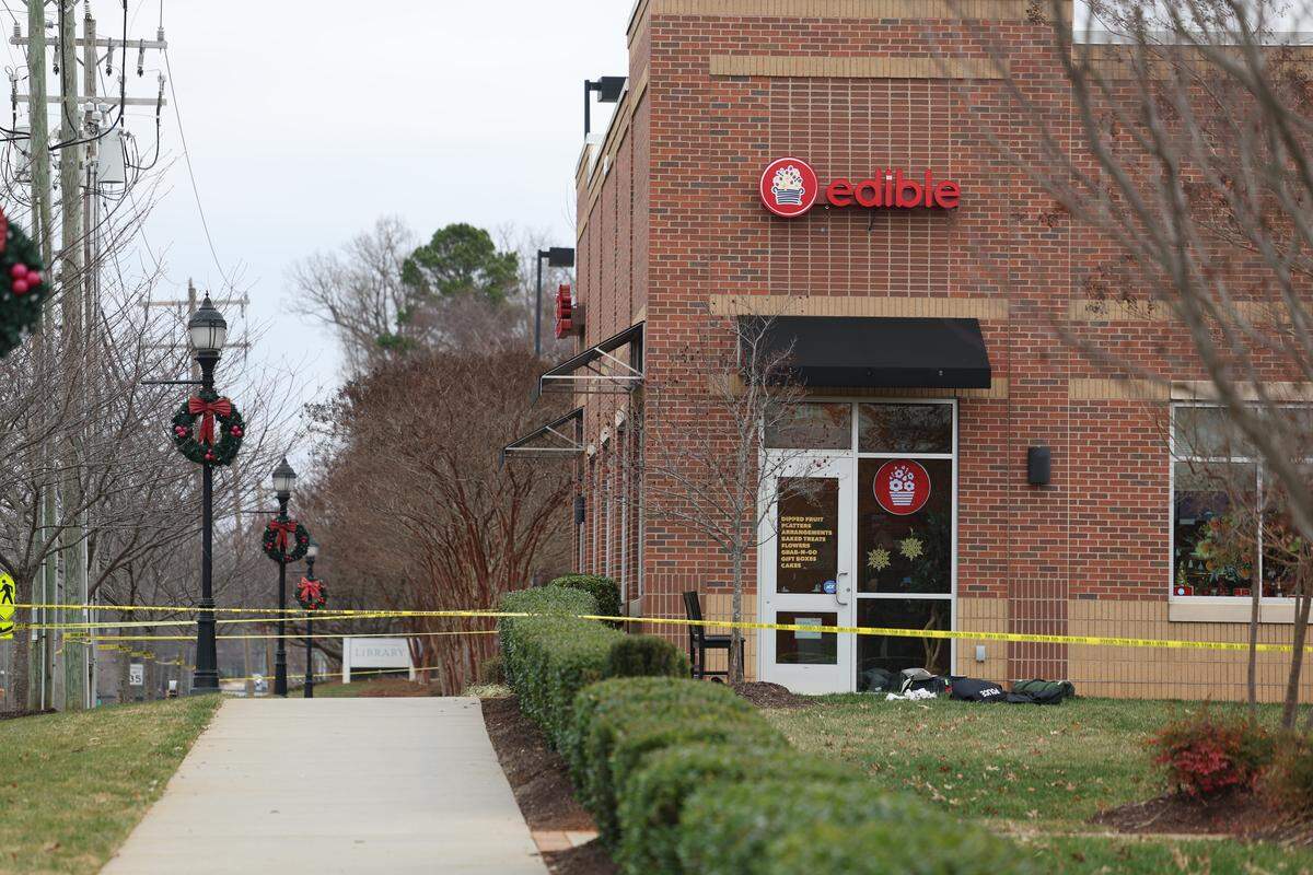 Police tape marks off the perimeter of a shopping center in Mint Hill on Friday. Two officers were shot, and a suspect is dead, officials said.