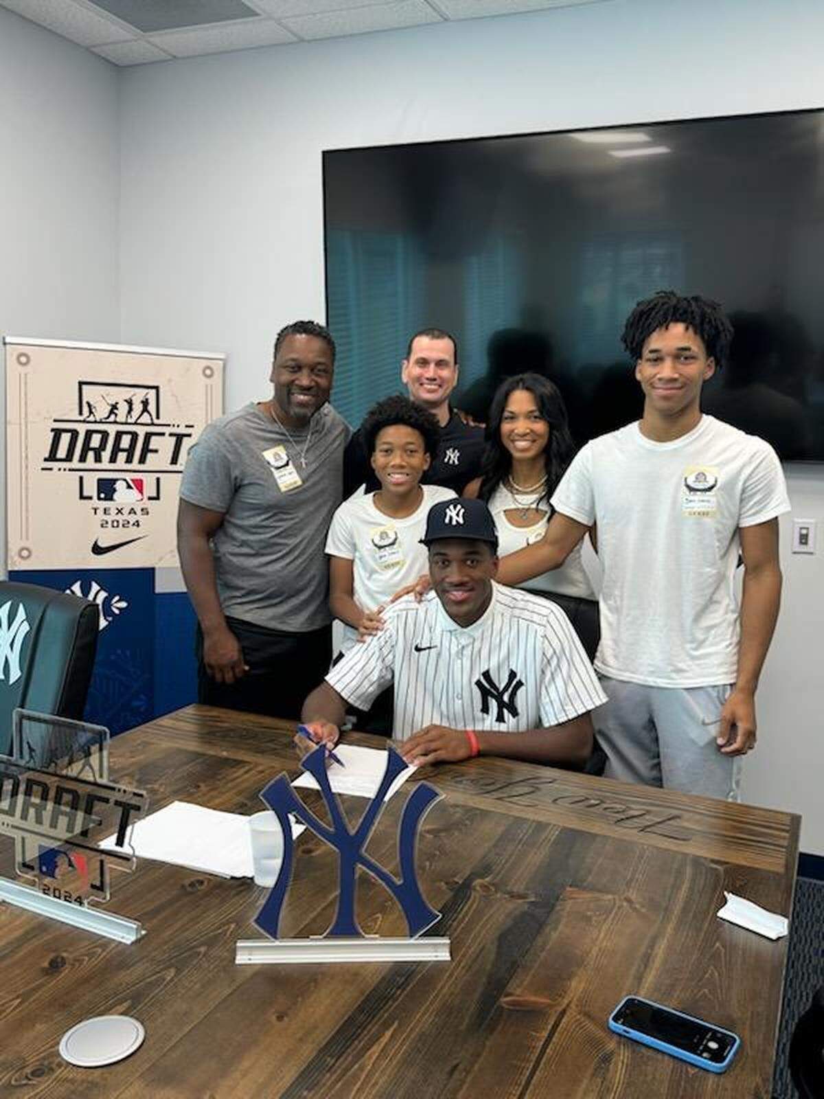 Dillon Lewis is surrounded by family members and New York Yankees scout Ricky Castle on signing day.