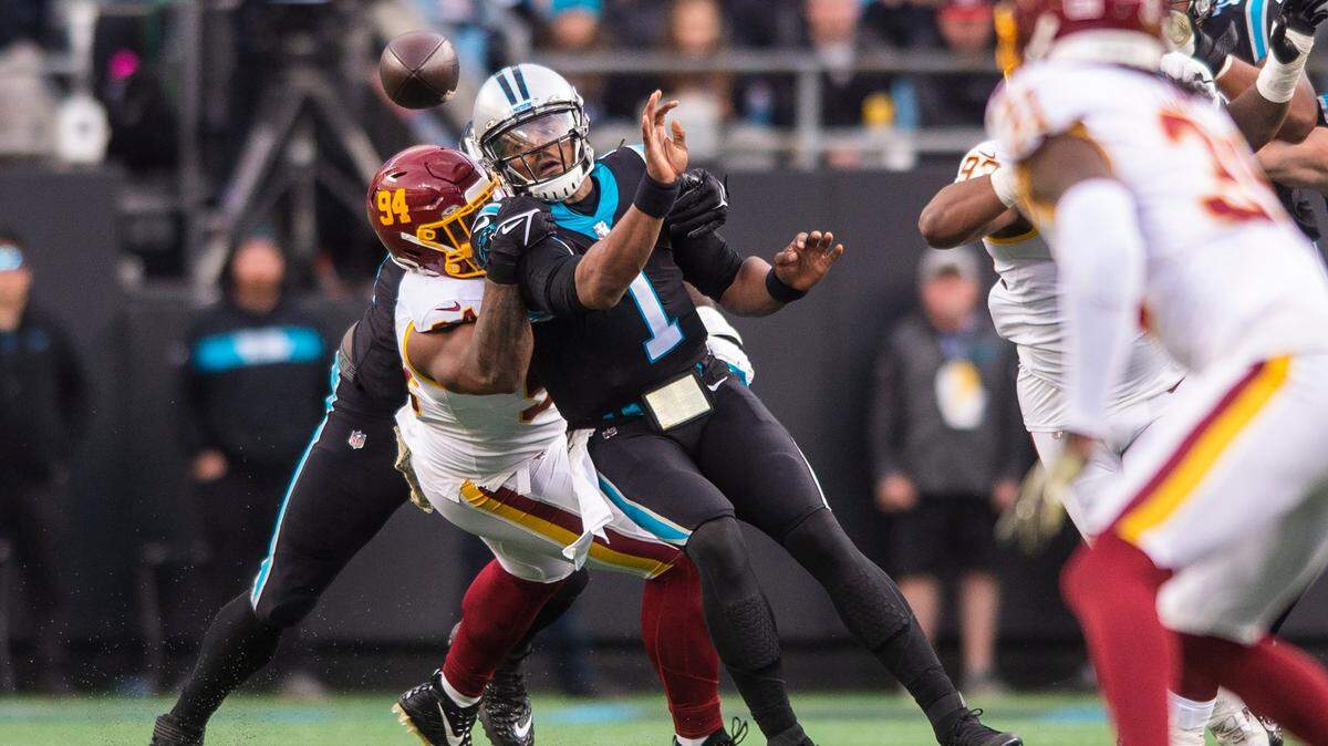 Panthers quarterback Cam Newton tries to get rid of the ball as the Washington Football Teams defense latches on at Bank of America Stadium on Sunday, November 21, 2021 in Charlotte, NC.
