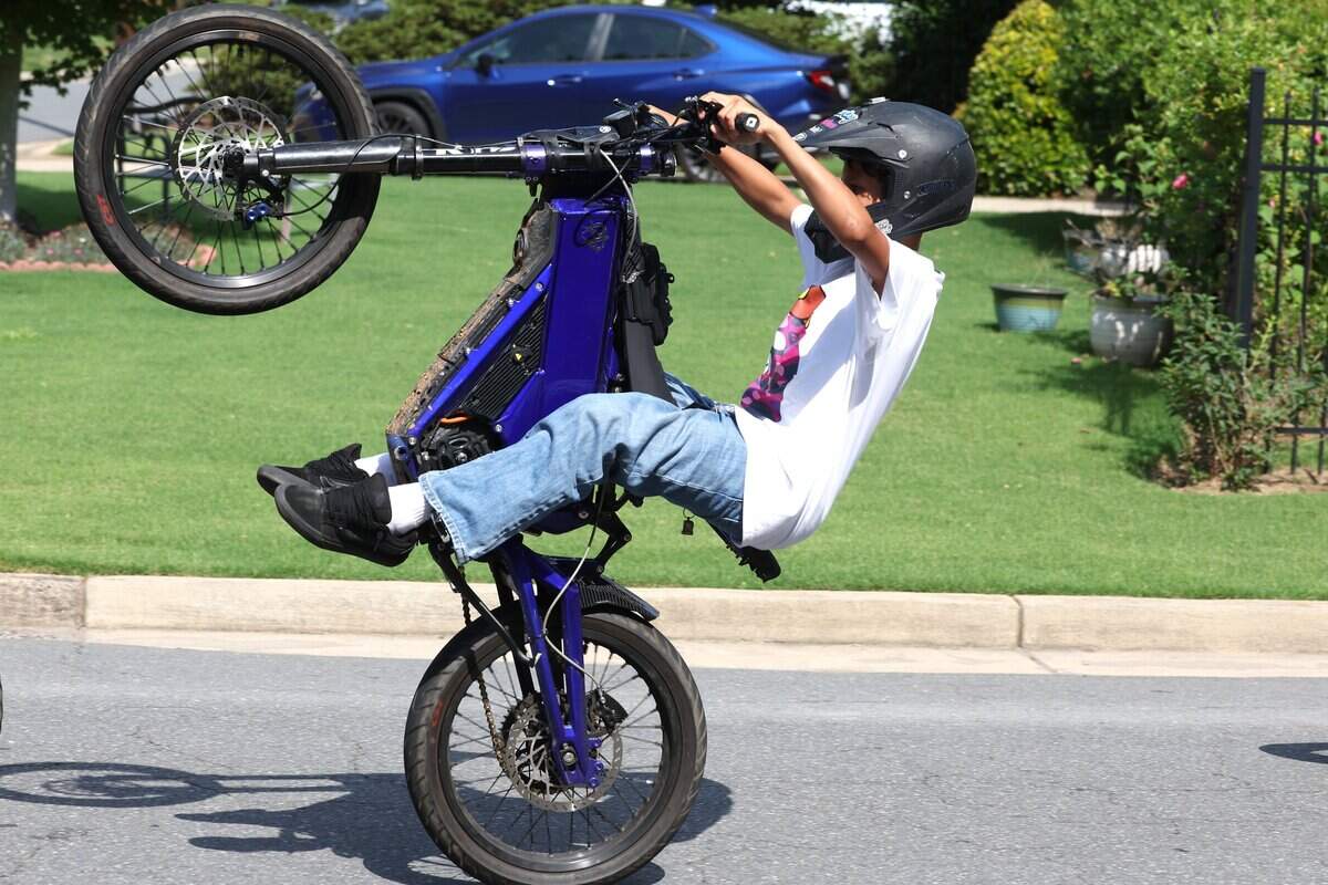 A youngster holds a wheeling on his e-bike as he travels down Westfield Road in Charlotte, NC on Tuesday, June 30, 2026.