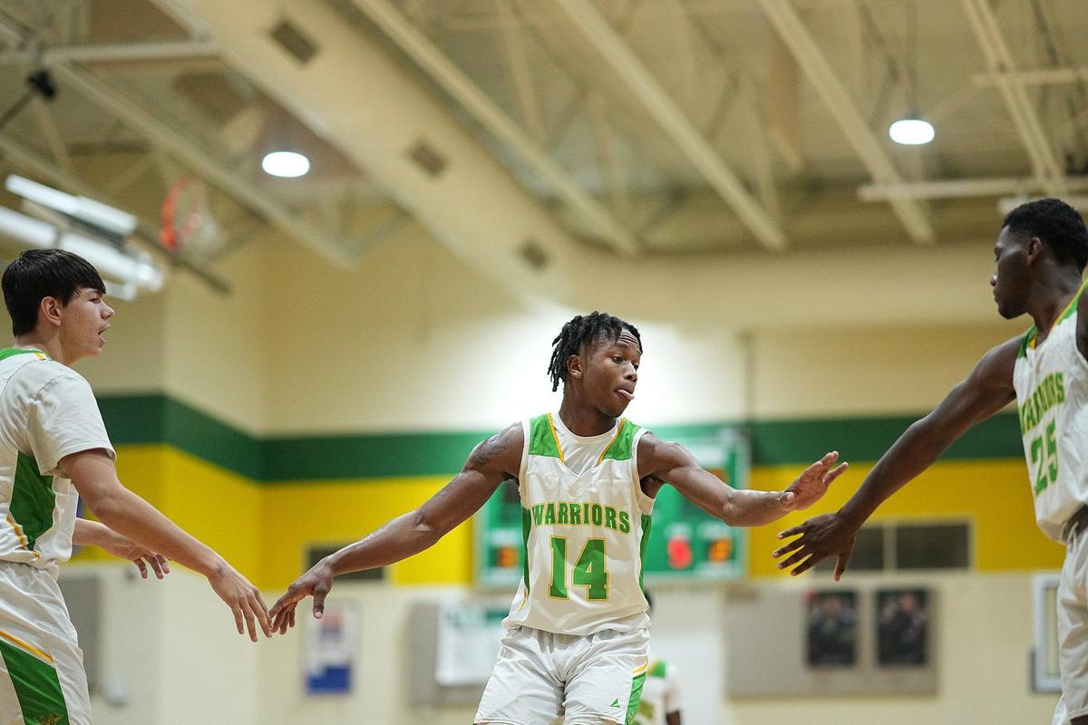 West Iredell’s Jordan Patterson (14) high-fives teammates Sebastian Bridges, left, and Thomas Colbert during the first half of a basketball game Friday, Dec. 20, 2024, in Statesville, N.C. (Charlotte Observer /Matt Kelley)