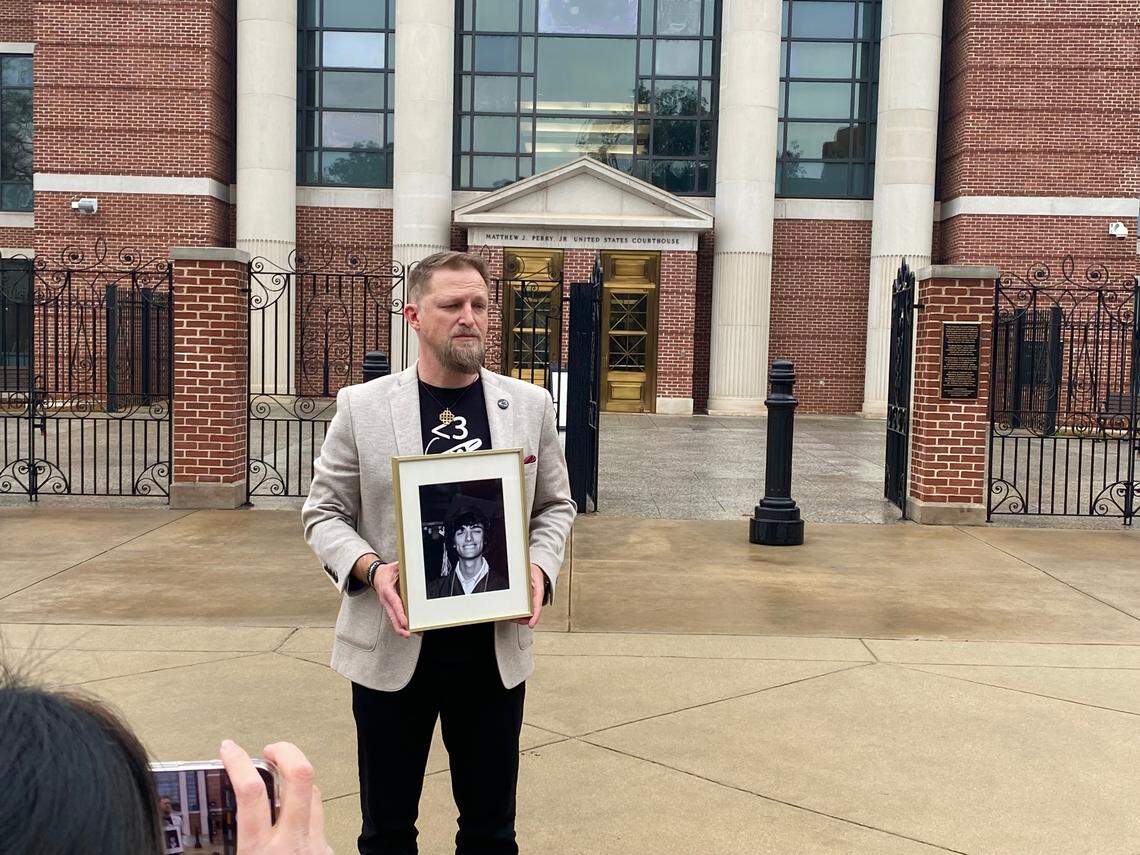 State Rep. Brandon Guffey of Rock Hill stands outside the federal courthouse in Columbia on Monday with a photo of his son, Gavin Guffey.