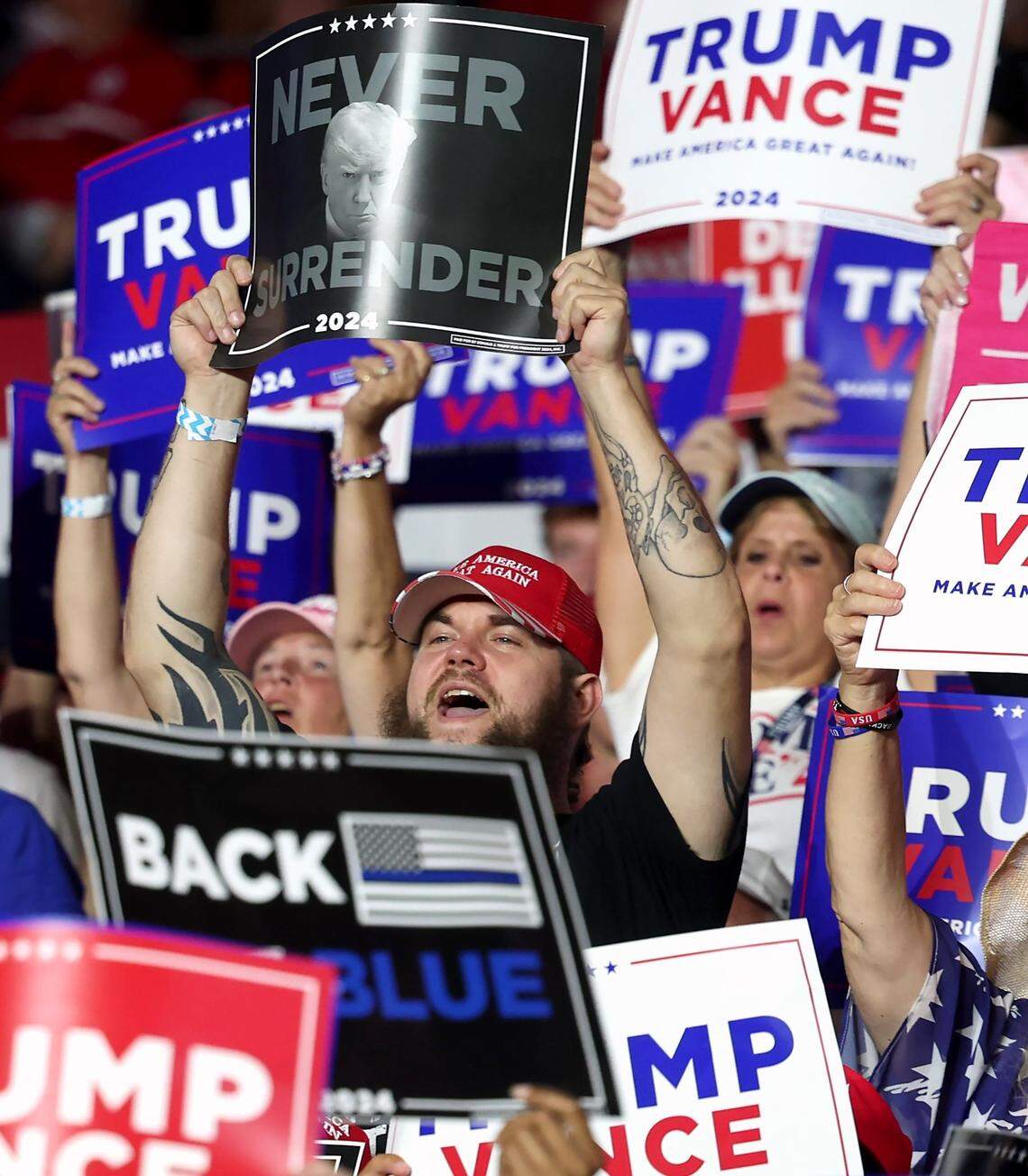 Supporters of the former President Donald Trump cheer and raise their signs high during a rally at Bojangles Coliseum in Charlotte, NC on Wednesday, July 24, 2024.