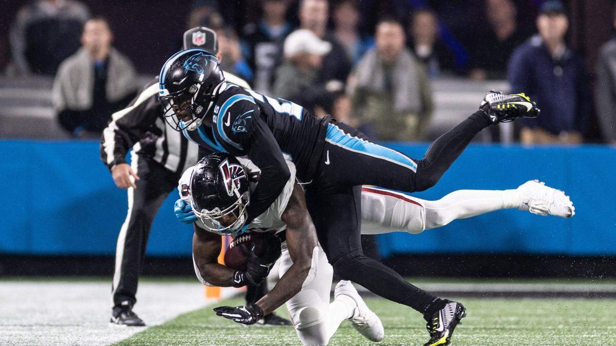Atlanta Falcons tight end Kyle Pitts, bottom, is tackled by Carolina Panthers safety Xavier Woods on Thursday, November 10, 2022.