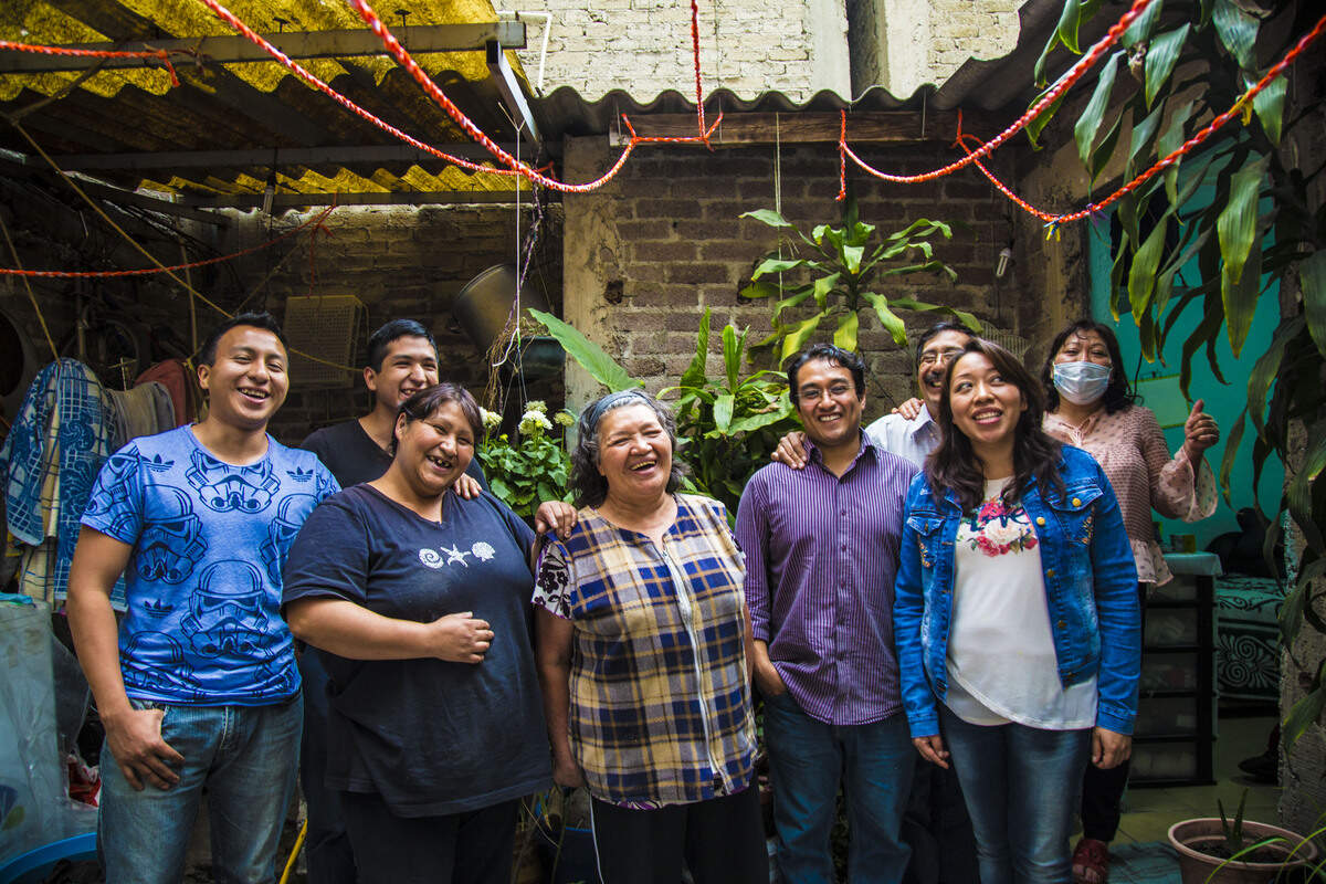 Maria Vázquez stands in the middle of her family on the patio of her home in Nezahualcóyotl, Mexico. Sam hasn't seen his grandmother, or any of his cousins, uncles and aunts pictured, since he was an infant.
