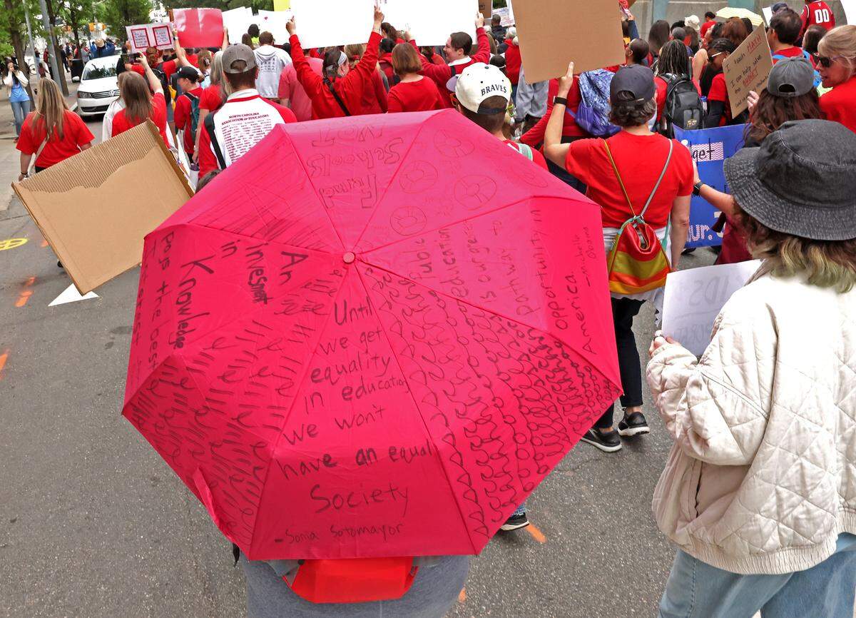 A marchers umbrella provides messages to others as they march through downtown Raleigh, NC on Friday, May 1, 2026 during a mass rally to protest the need for more funding for public schools.