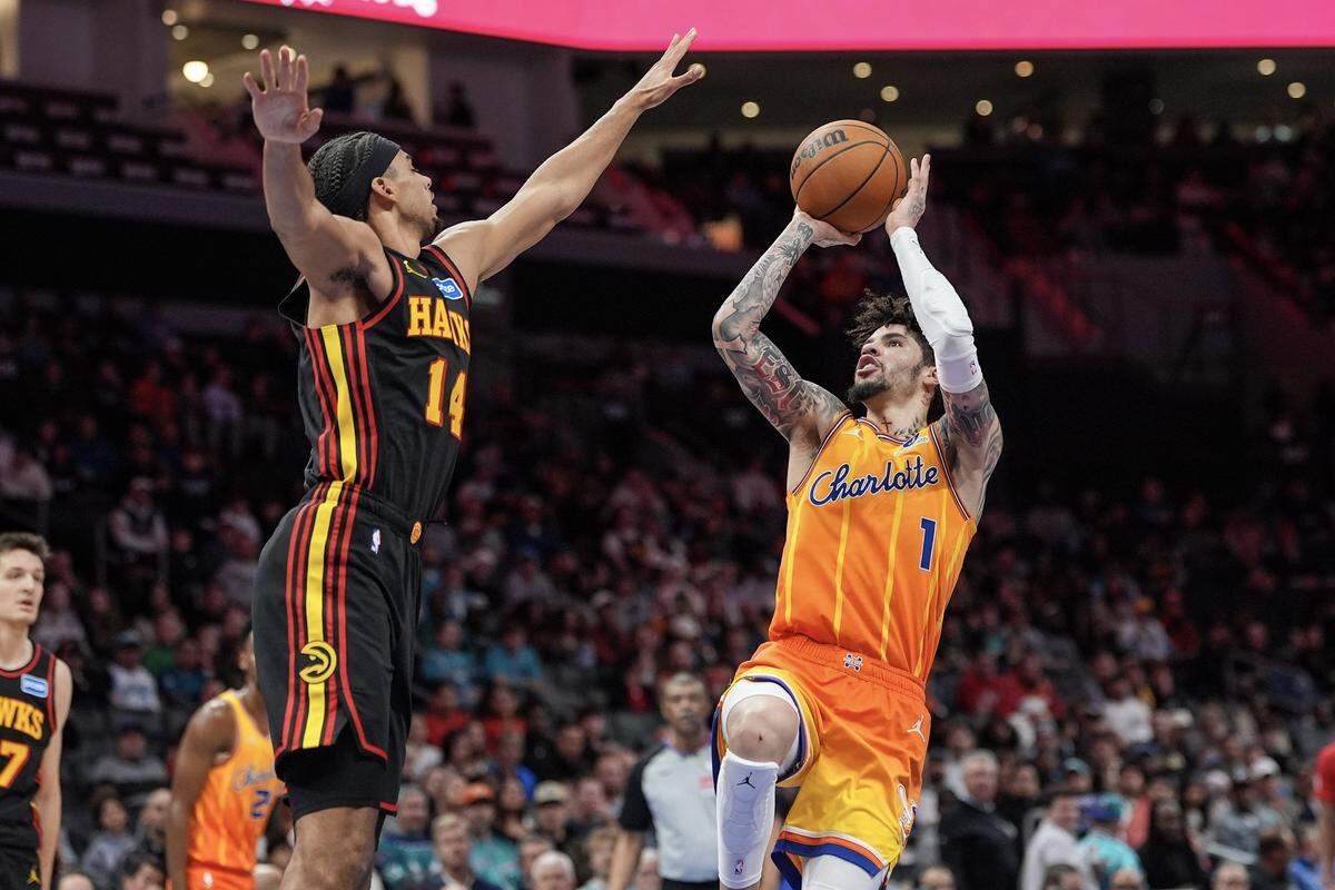 Charlotte Hornets guard LaMelo Ball (1) shoots over Atlanta Hawks forward Asa Newell during the first half of the game on Dec. 18, 2025, in Charlotte, North Carolina. 