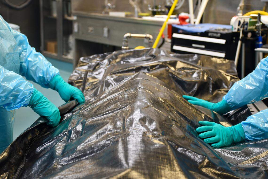 Two staff members at the chief medical examiner’s office in Raleigh prepare to transport a body. Medical examiner cases in North Carolina grew more than 30% over the past three years. A surge in drug overdose deaths is largely to blame.