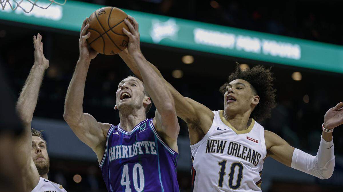 Charlotte Hornets center Cody Zeller, center, drives to the basket between New Orleans Pelicans forward Nicolo Melli, left, and New Orleans Pelicans center Jaxson Hayes in the first half of an NBA basketball game in Charlotte, N.C., Saturday, Nov. 9, 2019. (AP Photo/Nell Redmond)