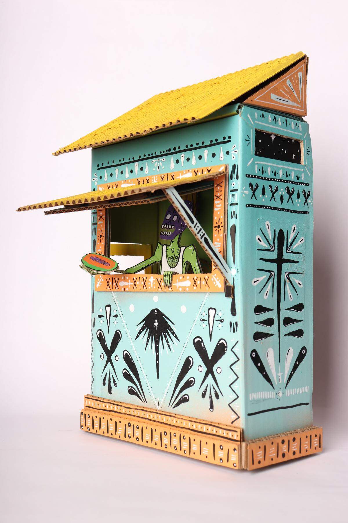 “Frutería” is a mixed media sculpture by Arko. He uses vivid colors to create a make-believe world for his main character, also called Arko.