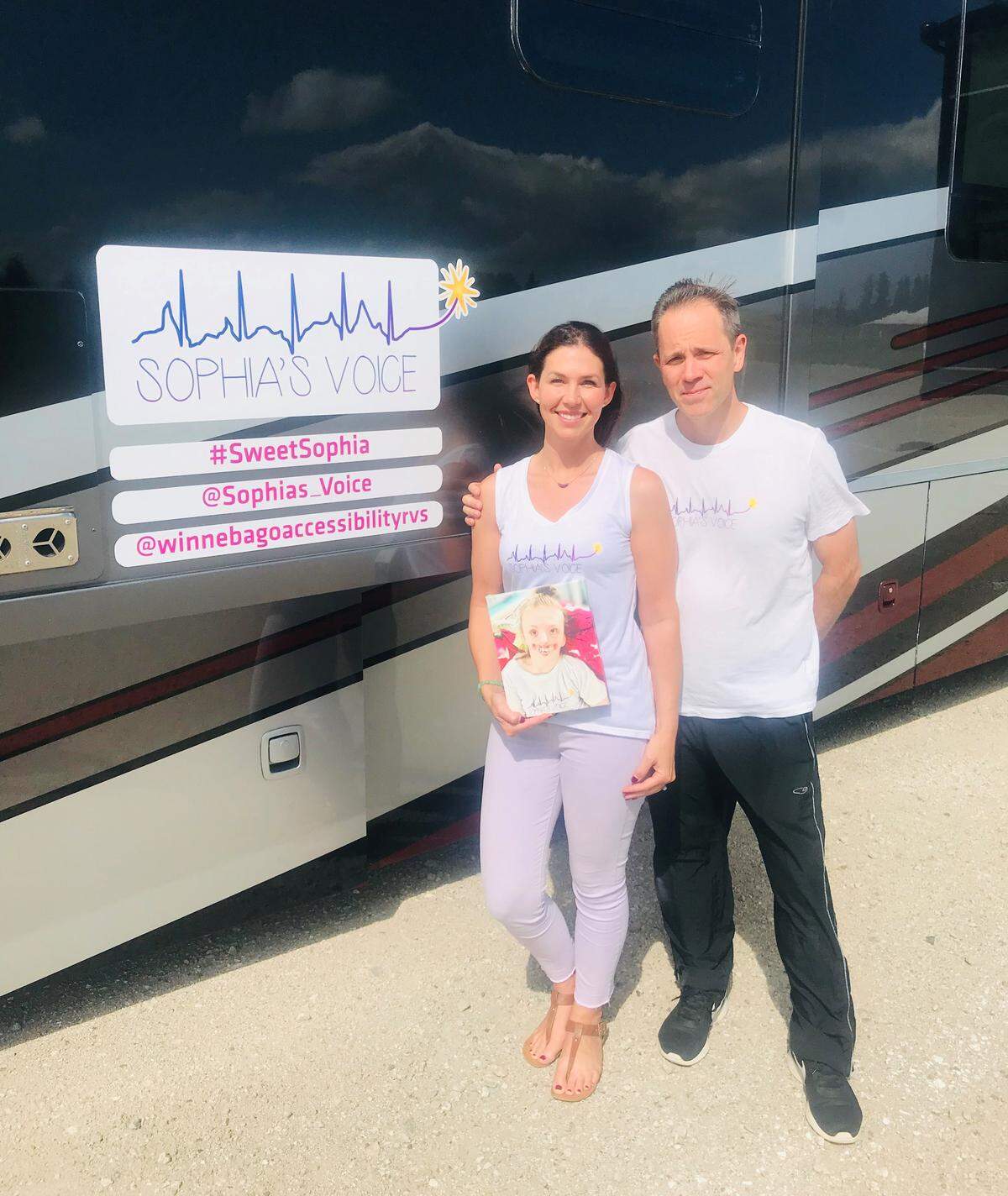 Natalie and Mark Weaver stand in front of the Winnebago the family will travel in for a month to honor their late daughter Sophia. The Winnebago company has gifted the family the month-long rental so they can make a cross country trip.