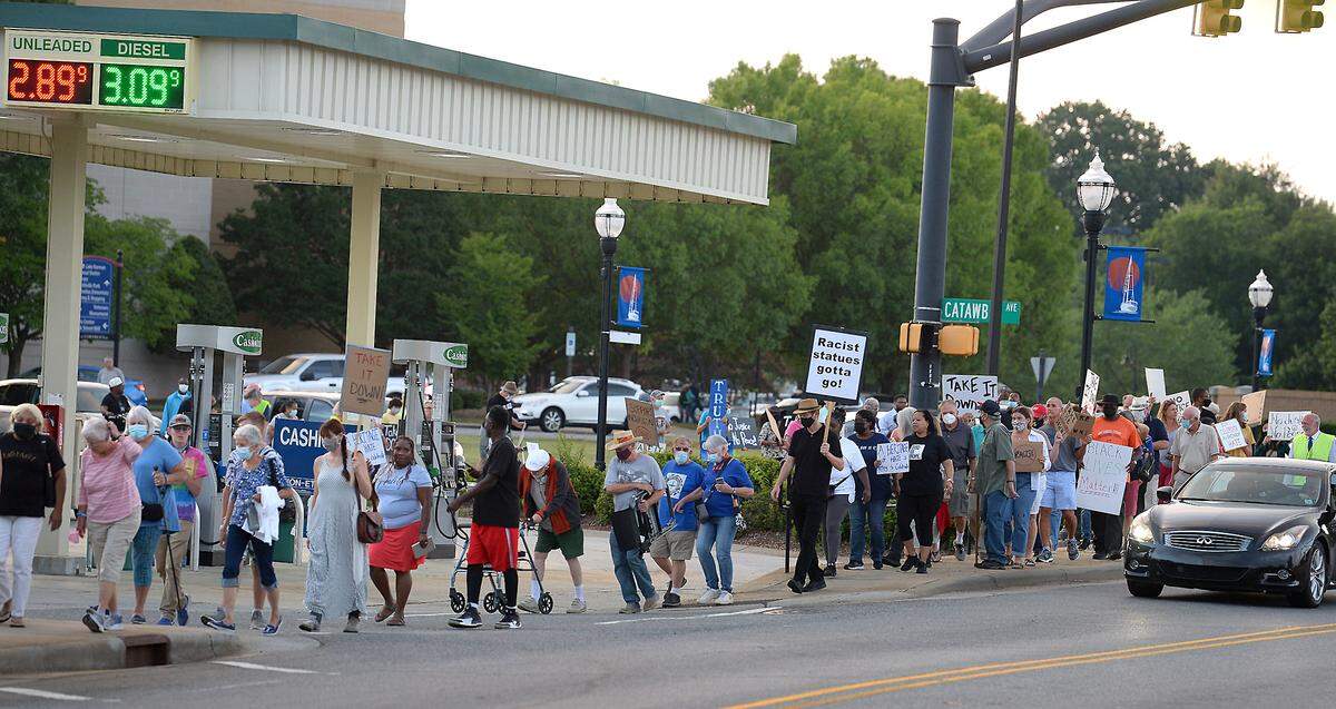 People attending the Unity in Community rally walk to the Confederate monument in the front yard of the Mt. Zion United Methodist Church in Cornelius, NC on Wednesday, August 4, 2021.The rally was held to urge the Mt. Zion Monumental Association to take down the Confederate monument.