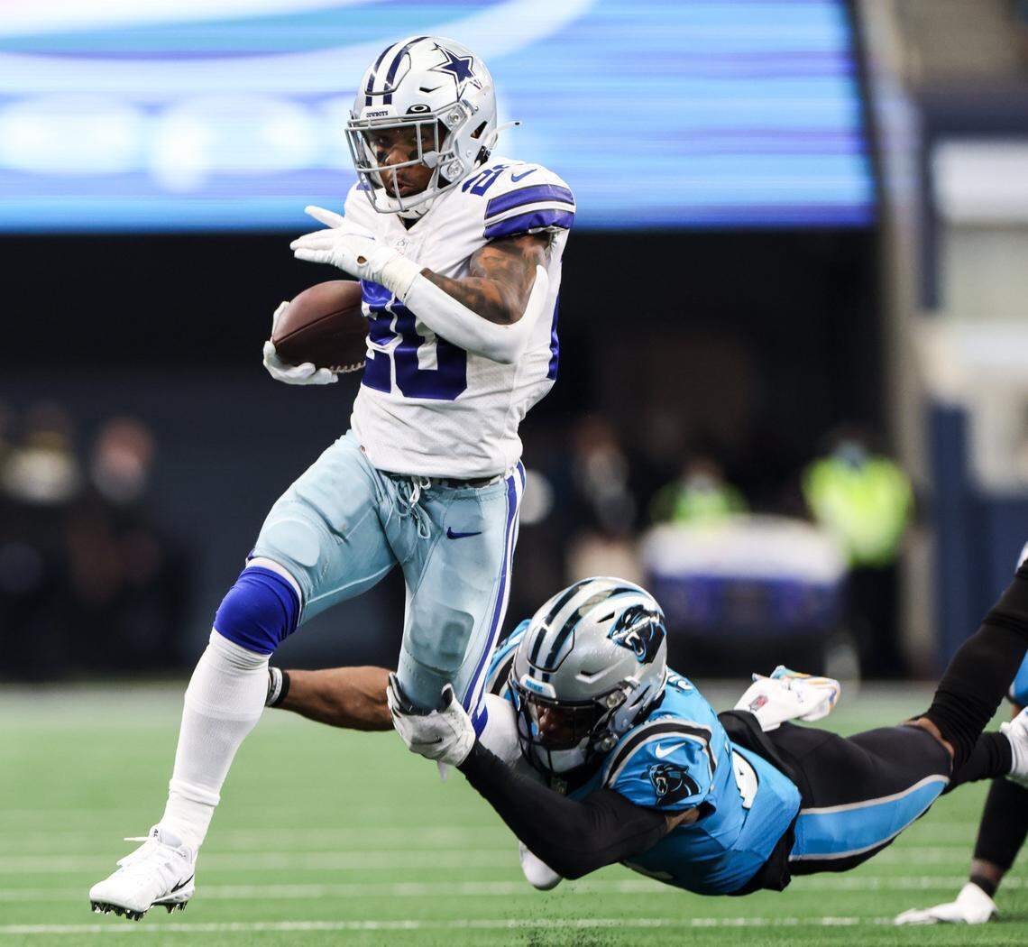 Dallas Cowboys running back Tony Pollard, left, tries to escape a tackle by the Carolina Panthers’ Jeremy Chinn on Sunday.