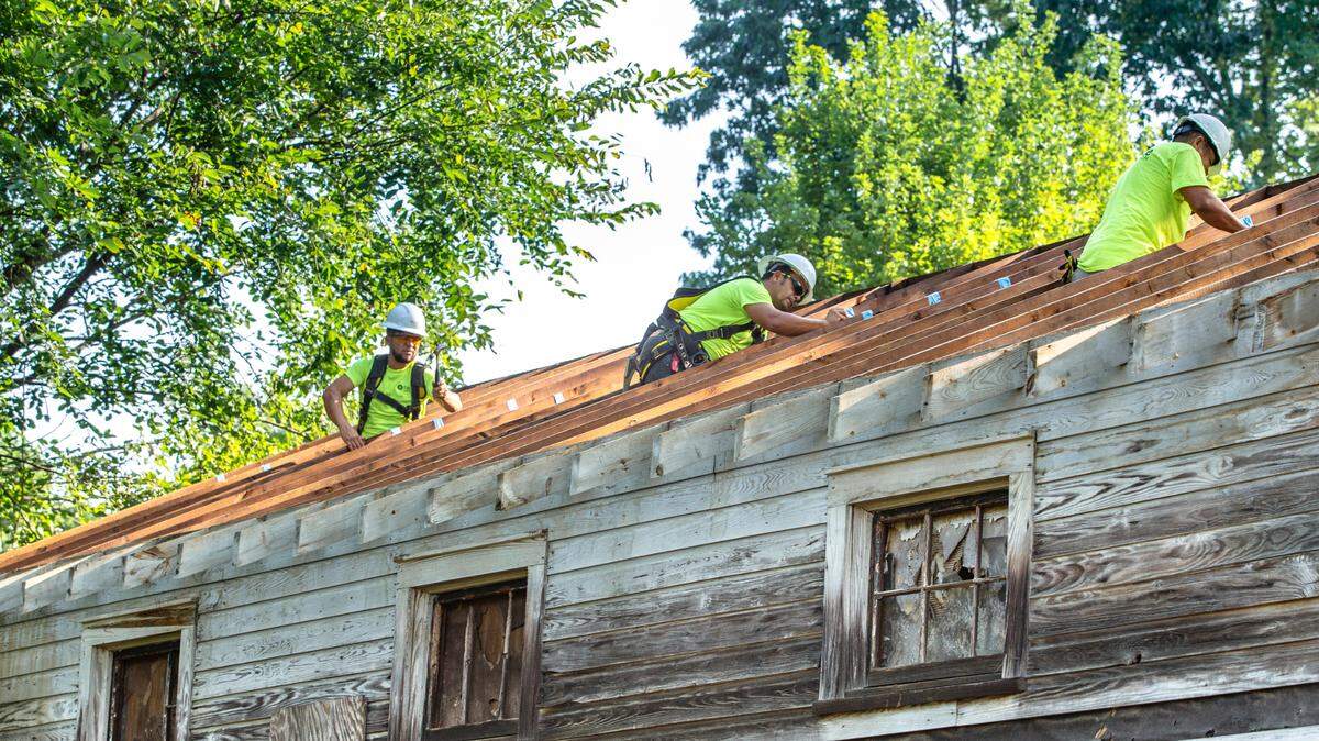Crews remove the roof from the historic Siloam School ahead of its transport to the Charlotte Museum of History where it will be restored as a community resource to preserve its legacy.