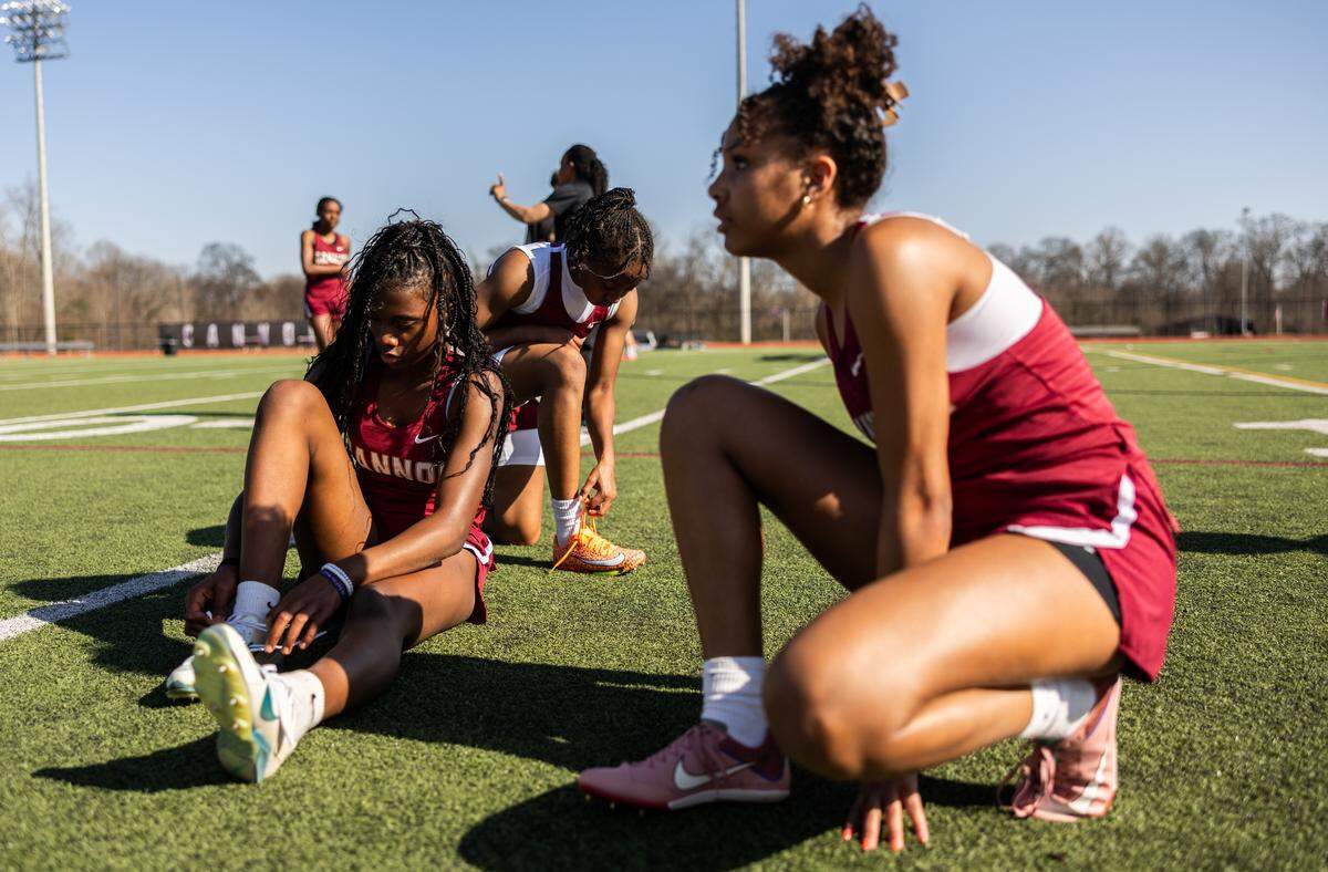 Kaylee Dobbins, right, with Cannon teammates Christina Hall, left, and Sakeenah Odom-Pollard, background, before a meet at the Concord school this past March.