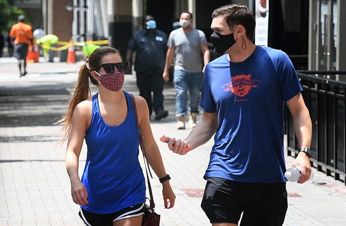 Mecklenburg County is considering a mask mandate amid rising cases of COVID-19 locally. Shown here, pedestrians wearing masks in uptown Charlotte.