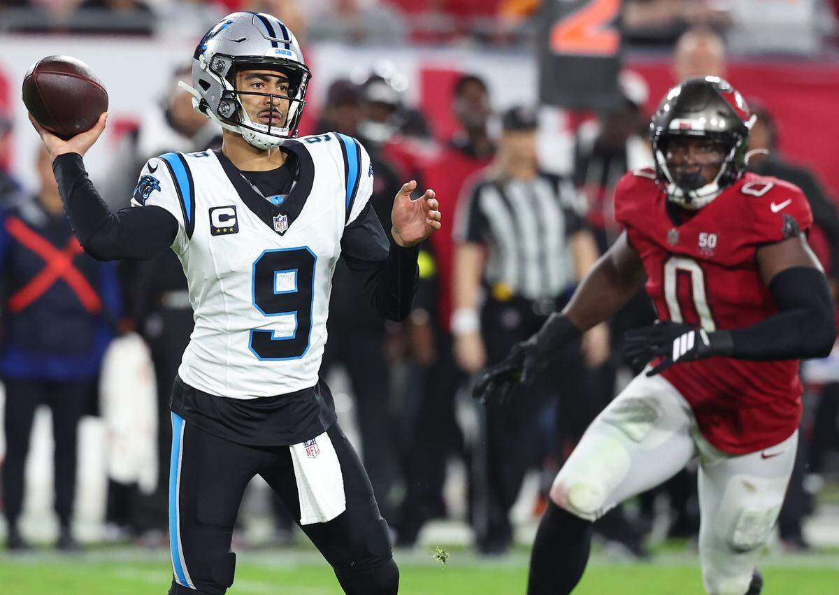 Carolina Panthers quarterback Bryce Young, left, looks to pass to a receiver as Tampa Bay Buccaneers linebacker Yaya Diaby, right, breaks around the outside during action at Raymond James Stadium in Tampa, FL. on Saturday, January 3, 2026. The Buccaneers defeated the Panthers 16-14.