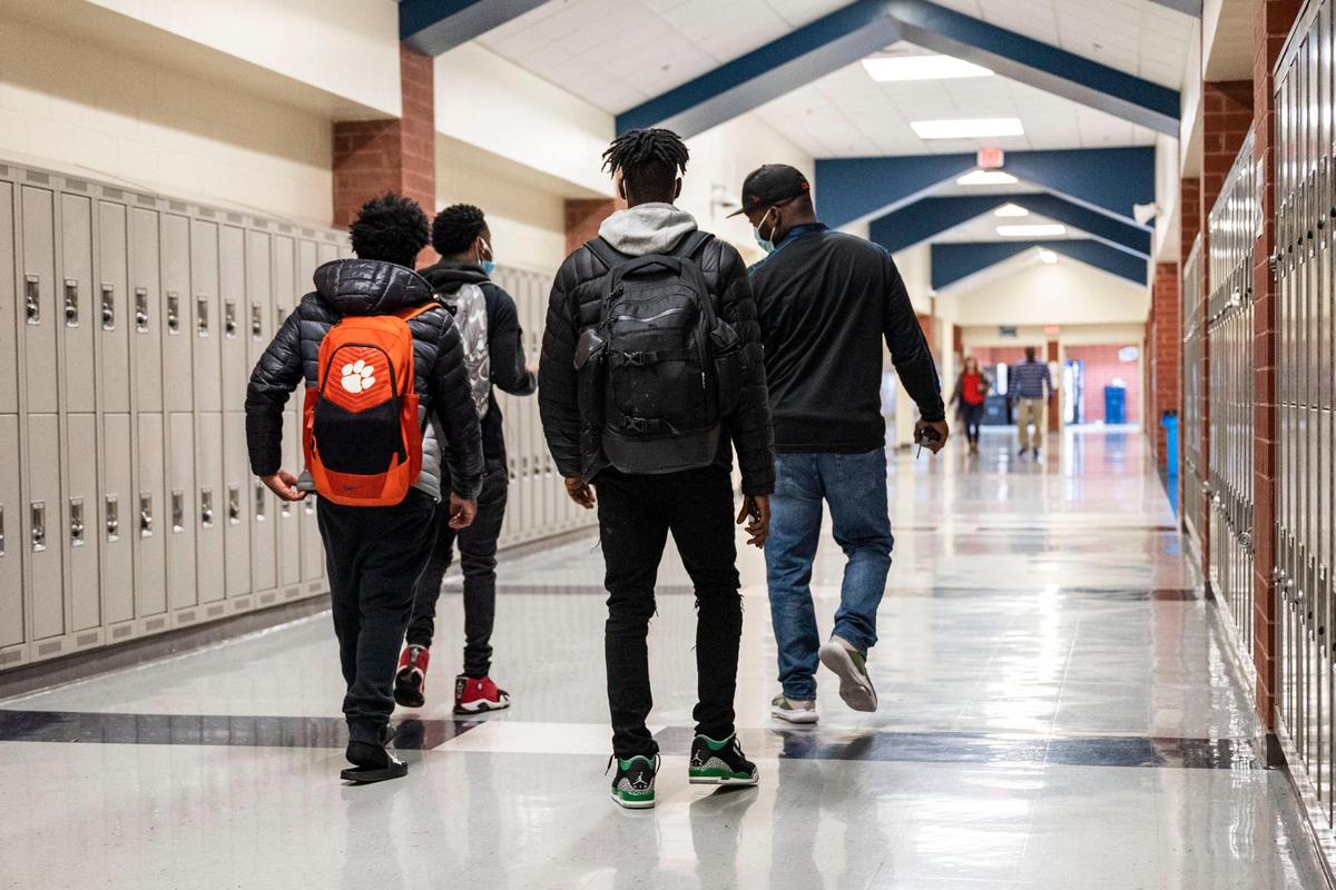 A parent volunteer walks down a hallway with a group of students at Hopewell High School in Huntersville in November 2021. A school safety expert says educators must address mental health in discussions with teens and parents to prevent violent incidents in the future.