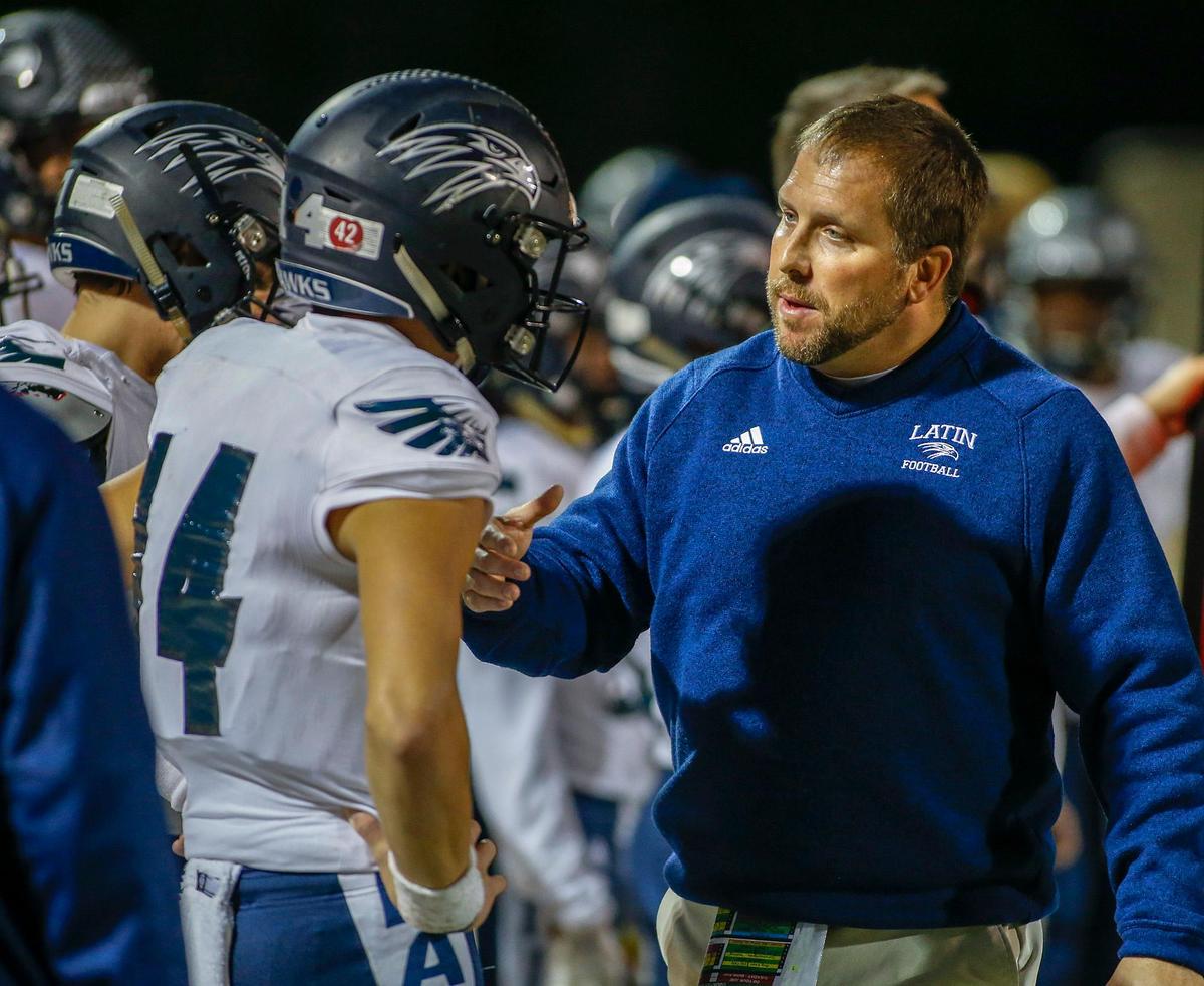 Charlotte Latin coach Justin Hardin chats with quarterback Jake Helfrich during Latin’s 31-16 win over rival Charlotte Country Day Thursday.