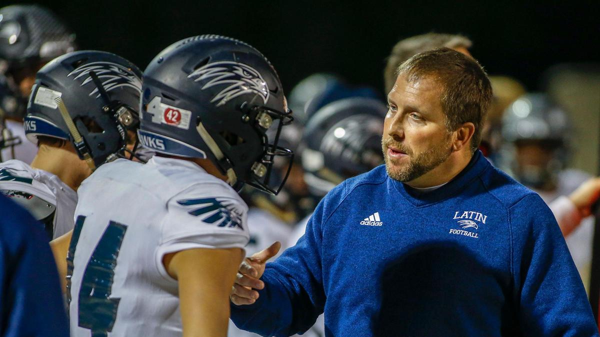 Charlotte Latin coach Justin Hardin chats with quarterback Jake Helfrich during Latin’s 31-16 win over rival Charlotte Country Day Thursday.