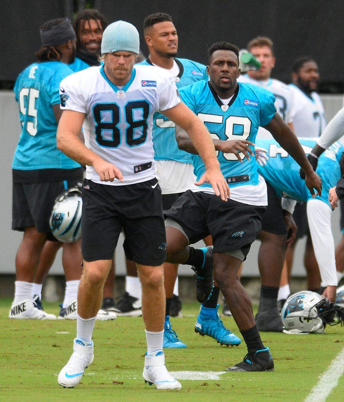 Carolina Panthers tight end Greg Olsen (88) and linebacker Thomas Davis (58) warm up together in 2018.