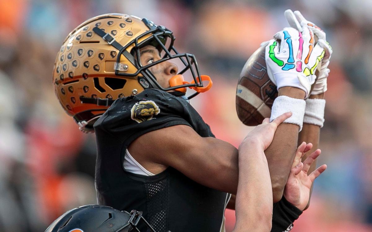 Shelby’s Ja’Keith Hamilton (4) pulls in a touchdown pass in the second quarter over Wallace-Rose Hill’s Reid Page (13) during the NCHSAA 2-A championship game on Saturday, December 11, 2021 at Carter-Finley Stadium in Raleigh, N.C.