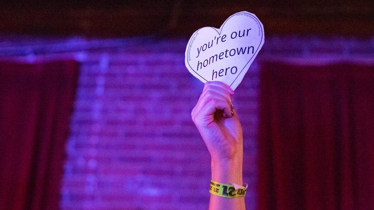 A fan holds a heart declaring Charlotte pride for Reneé Rapp.