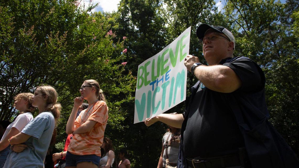 Glen Stephens holds a sign in showing support for victims of sexual assault and rape while at a protest against sexual assault at Myers Park High School on Tuesday, June 29, 2021.