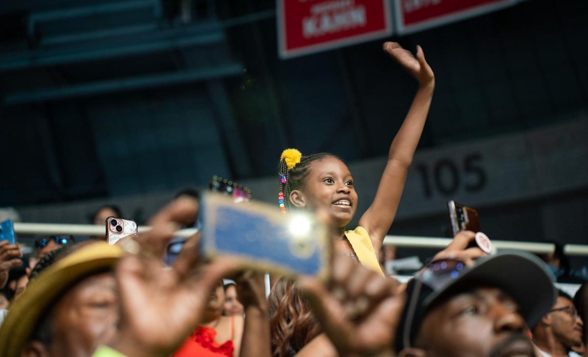 A member in the audience of the David W. Butler High School graduation ceremony waves to grads at the Bojangles Coliseum in Charlotte on Monday, June 10, 2024.
