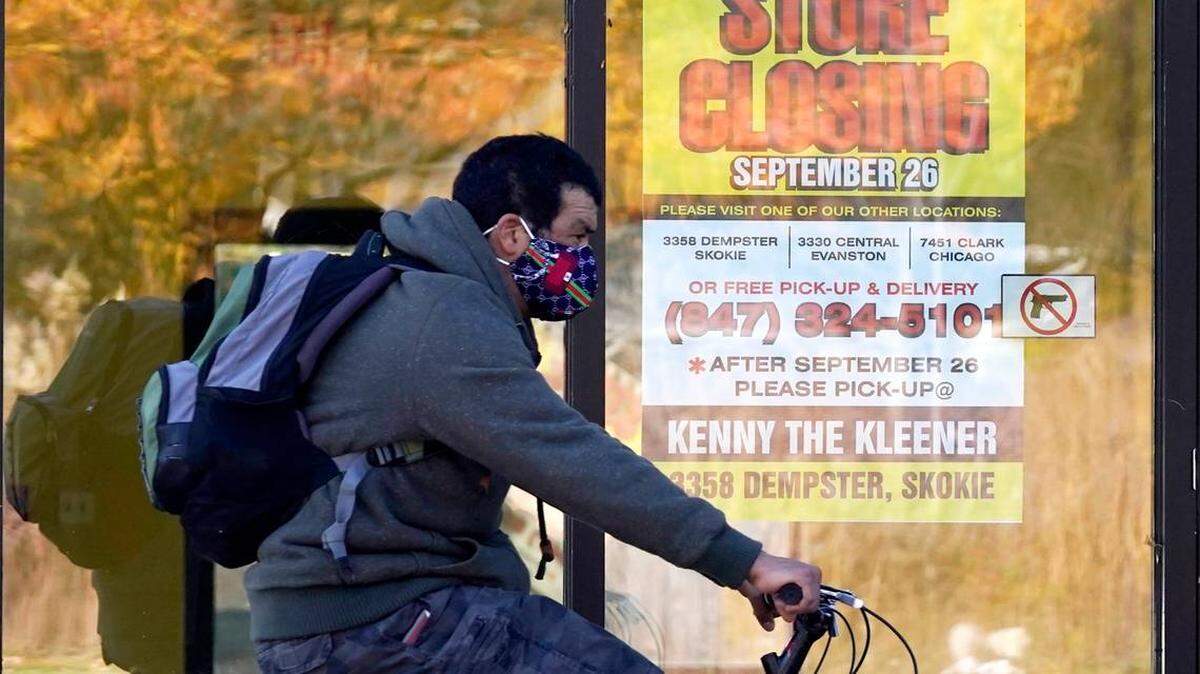 As businesses close and unemployment rises amid the coronavirus outbreak, states are renewing their push for more federal money to deal with the fallout. Here, a man rides his bike past a closed store in Wilmette, Ill.