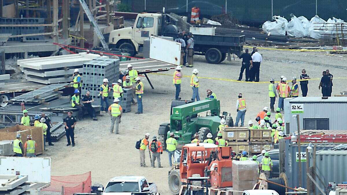 Charlotte Mecklenburg Police officers and construction workers gather at the scene where a worker fell to his death on Wednesday.