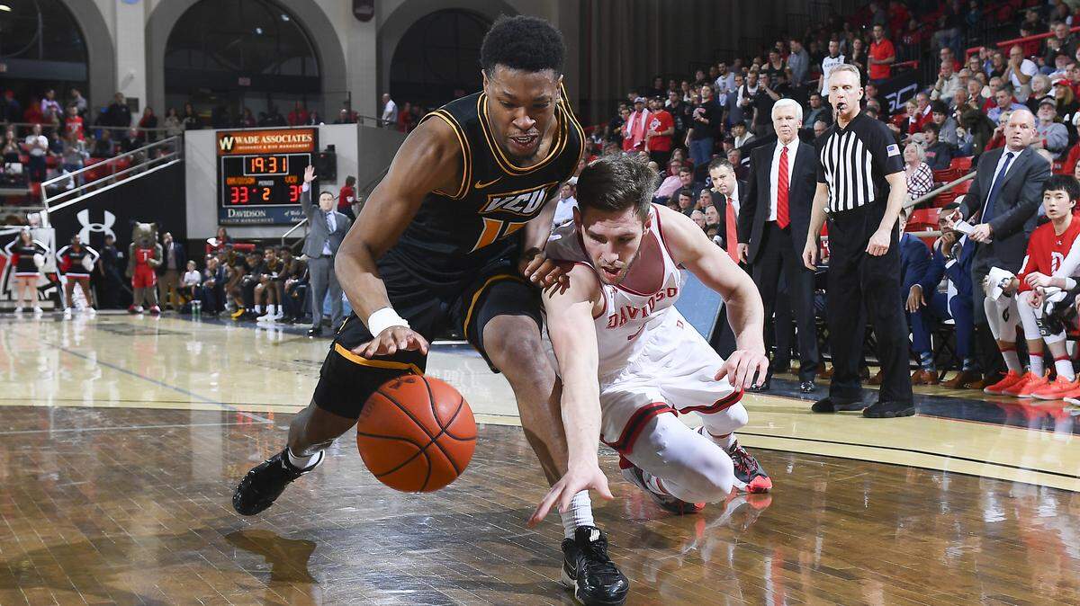 Davidson’s Jon Axel Gudmundsson (left) and VCU’s KeShawn Curry go for a loose ball in the Wildcats’ 75-65 victory Friday.