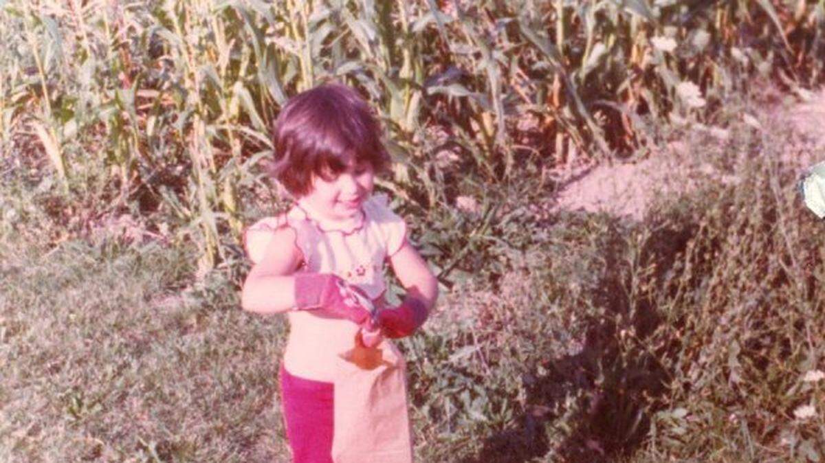 A 3-year-old Jodie Valade picks green beans from her family’s garden.