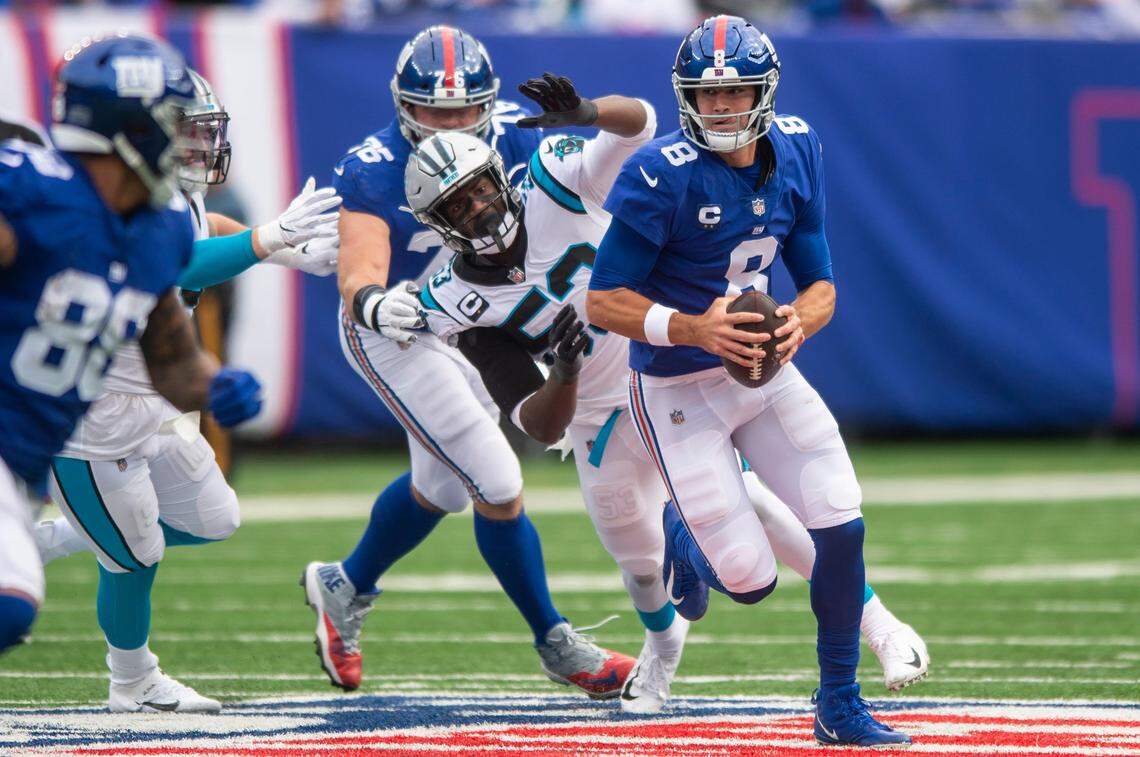 Panthers defensive end Brian Burns, back center, reaches for Giants quarterback, Daniel Jones, during the game against the Giants at MetLife Stadium on Sunday, October 24, 2021 in Rutherford, NJ. The Panthers, who did not score a single touchdown, lost to the Giants, 24-3. This is the Panthers fourth straight loss after a 3-0 start to the season.