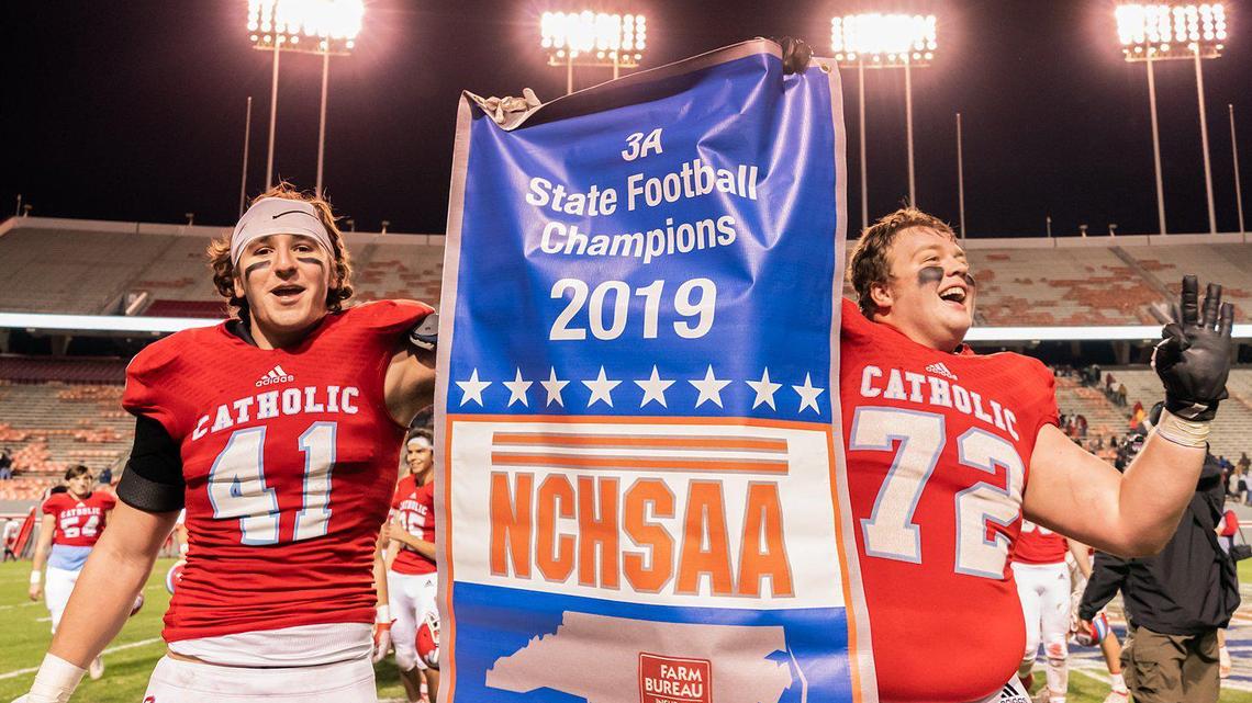 Charlotte Catholic players Connor Dougherty (41) and Carter Wood (72) celebrate their 23-7 victory over Southern Nash.