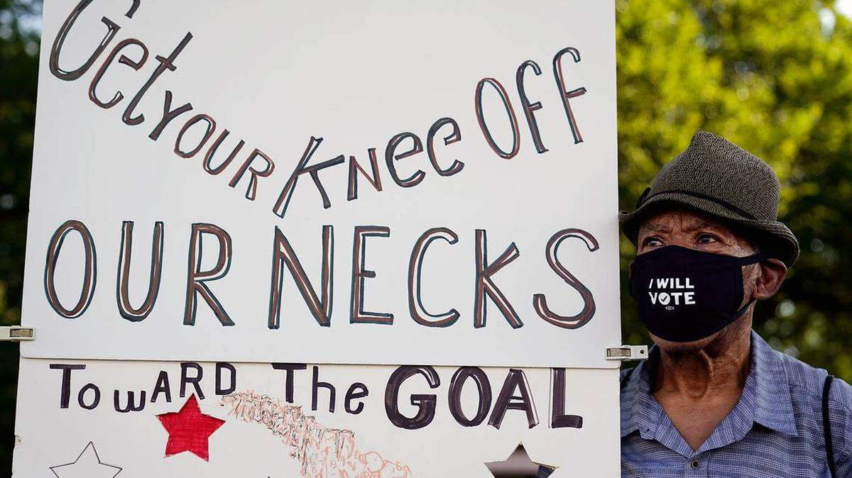 Walter Carter, 74, of Gainesville, Fla., holds up a sign near the Lincoln Memorial on Aug. 28, 2020. He’s one of 50,000 people expected to attend a weekend march calling for police reform. The event is dubbed the “Get Your Knees Off Our Necks” March and marks the 57th anniversary of the Rev. Martin Luther King Jr.’s “I Have A Dream” speech. 