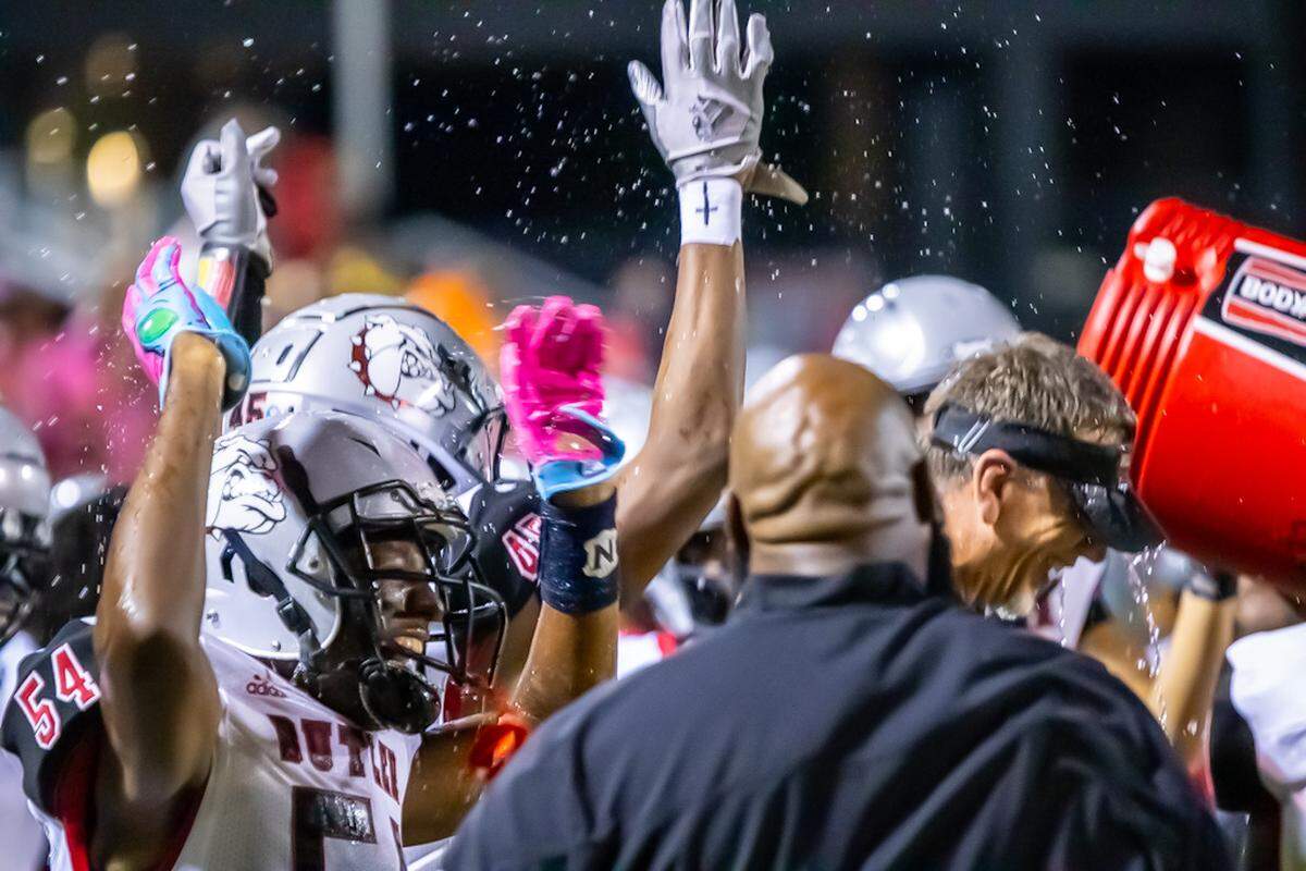 Butler Head Coach Brian Hales and team celebrate a win over Charlotte Catholic after the game