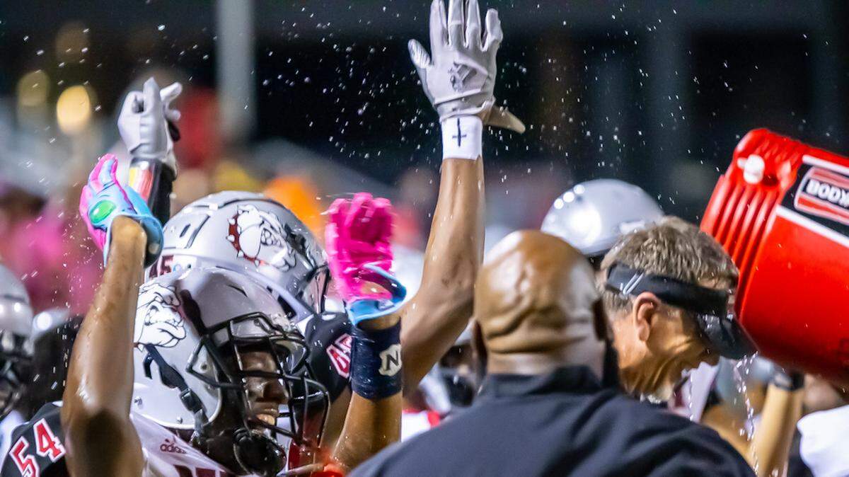 Butler Head Coach Brian Hales and team celebrate a win over Charlotte Catholic after the game