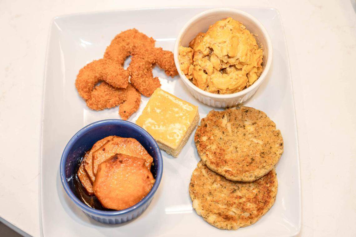 A VelTree Soul Plate with fried shrimp, yams, krab cake patties, cornbread, and mac and cheese.