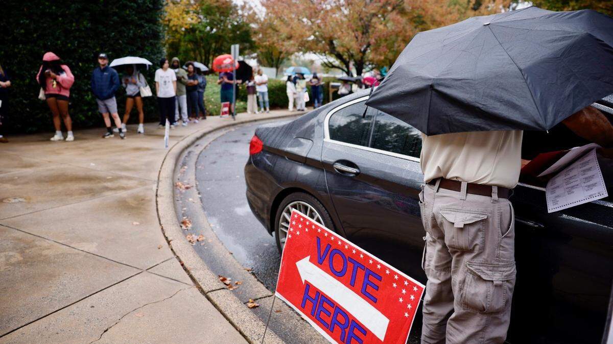 A poll worker brought a ballot to a voter in a car at Charlotte Mecklenburg Library at University City on Nov. 5, 2024.