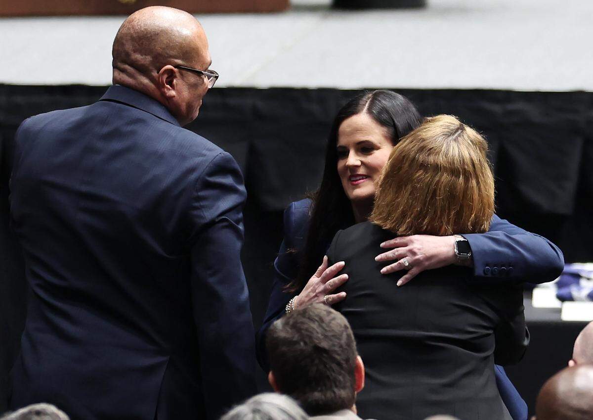 Kelly Weeks, center, the widow of slain Deputy U.S. Marshal Thomas Weeks Jr., hugs attendees her husband’s memorial service as she went to the podium to speak at Bojangles Coliseum in Charlotte, NC on Monday, May 6, 2024. U.S. Marshal Weeks Jr., died during a standoff with a gunman on Monday, April 29th 2024.