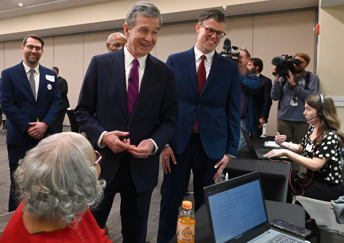 North Carolina Governor Roy Cooper, center and NC Department of Health and Human Services Secretary Kody Kinsley, right, meet with navigators and clients during the launch of Medicaid Expansion Friday, December 1, 2023 at the Goodwill Opportunity Campus in Charlotte, NC. The expansion will give more than 600,000 North Carolinians access to health care. 